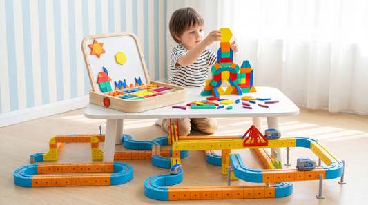 Un niño agregando una ficha magnética a una construcción alta, con una pista de tren magnética que se curva por debajo.